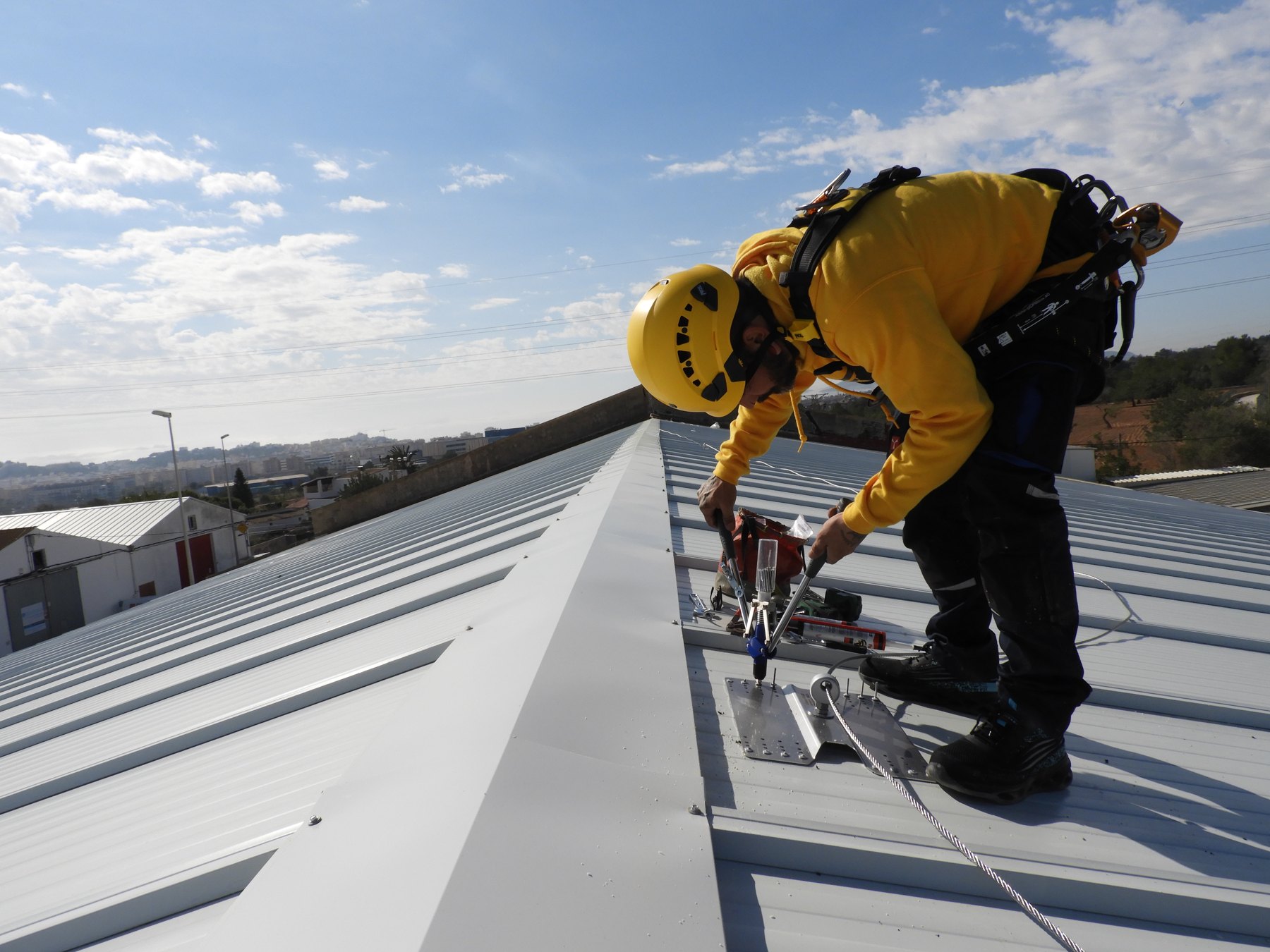 Técnico instalando una línea de vida sobre la cubierta de la nave de Maripol Royal