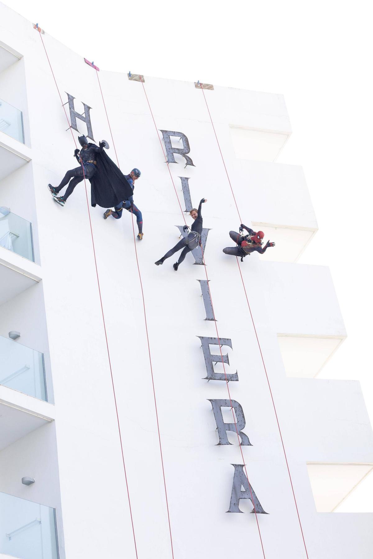El equipo disfrazado de superhéroes descendiendo por una fachada para dar la bienvenida a las familias de El descanso del guerrero